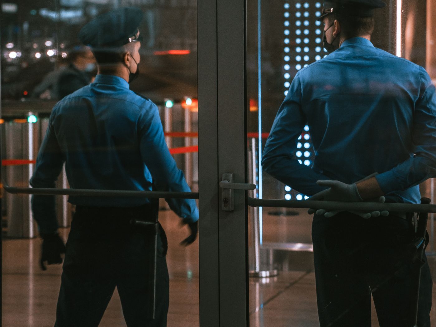 Two officers holding a lit building entrance after dark